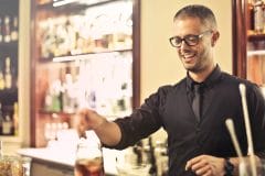 smiling bartender making a cocktail