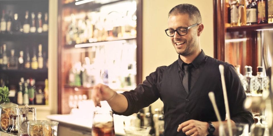 smiling bartender making a cocktail