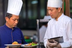 executive chef inspecting dish