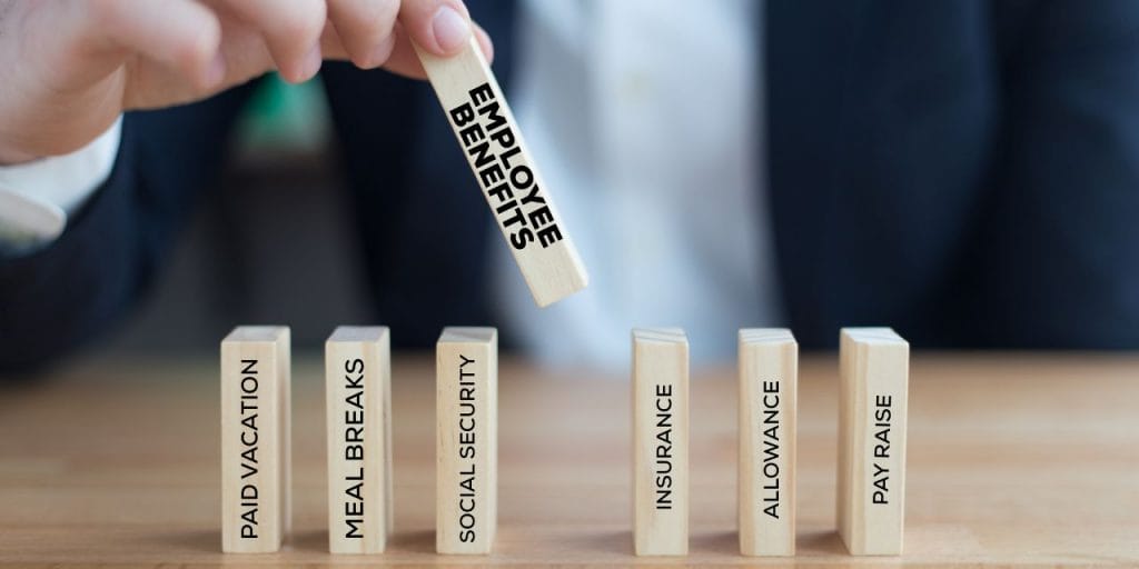 different employee benefits written on wooden cuboids