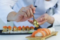 sushi chef carefully fixing plate