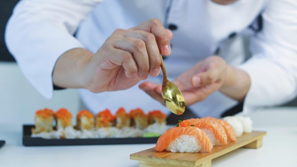 sushi chef carefully fixing plate