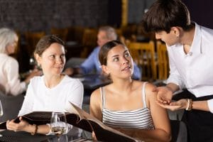 server talking to restaurant guests