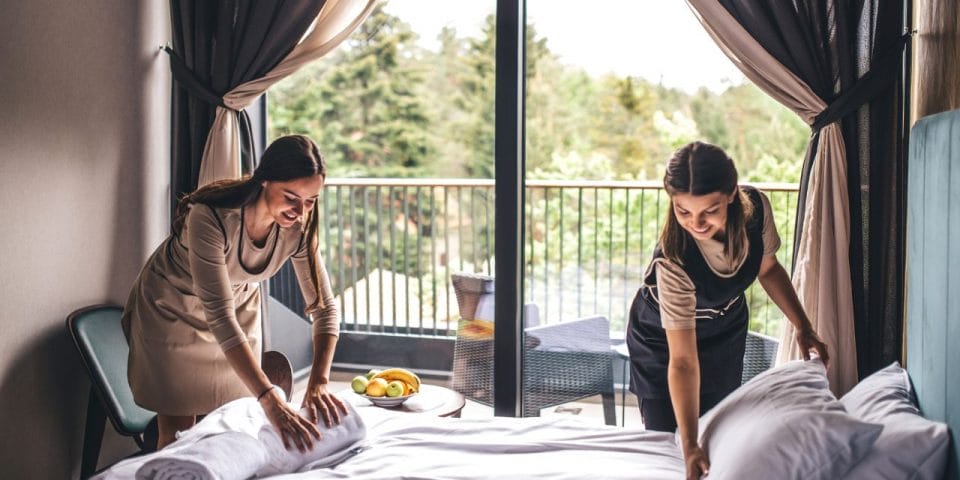 two housekeepers making the hotel bed