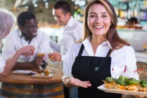 smiling server holding a plate with food