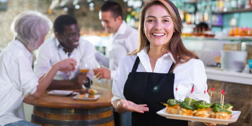 smiling server holding a plate with food