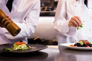 station chefs adding seasoning to meal