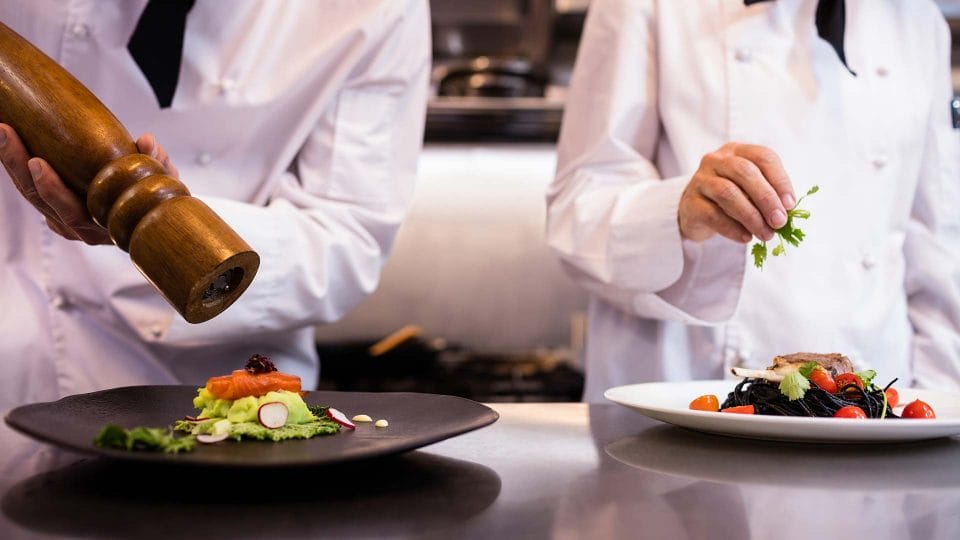 station chefs adding seasoning to meal